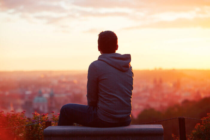 Young man is looking at the sunrise