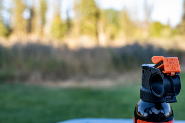 Aerosol trigger of a can of bear spray in an outdoor setting. High quality photo