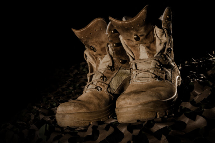 military boots on camouflage net and black backround