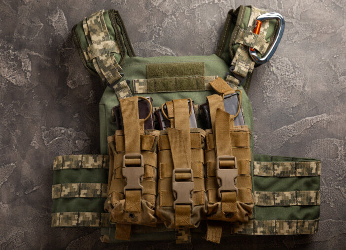 Military body armor on a black marble table. army bulletproof vest. View from above. Military concept.