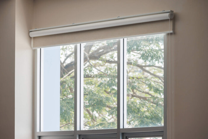 white roller blind curtain of the house window. modern blinds Roller sun protection in the office building.