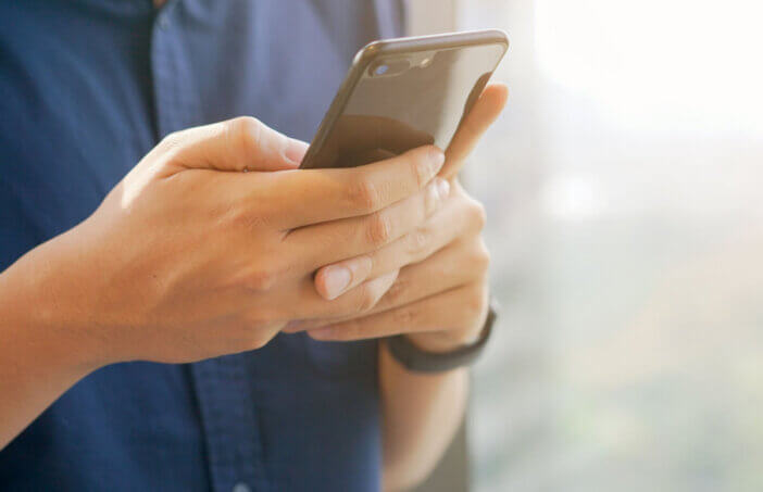 close up businessman holding smartphone for checking work or make appointment and using application for manage job or surf the internet at outside office , technology lifestyle concept