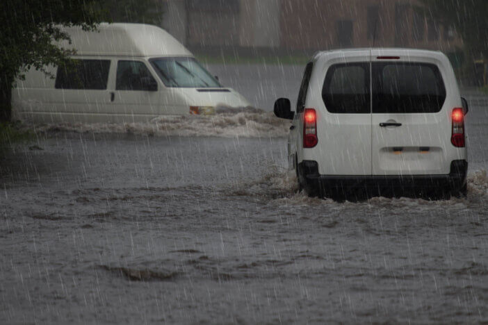 Cars on a flooded city road at the rain day.