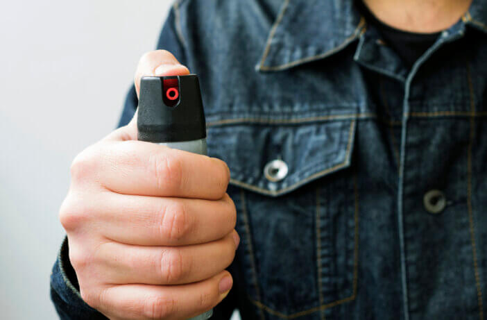 Tear gas or pepper spray in male hand. Means of self-defense.