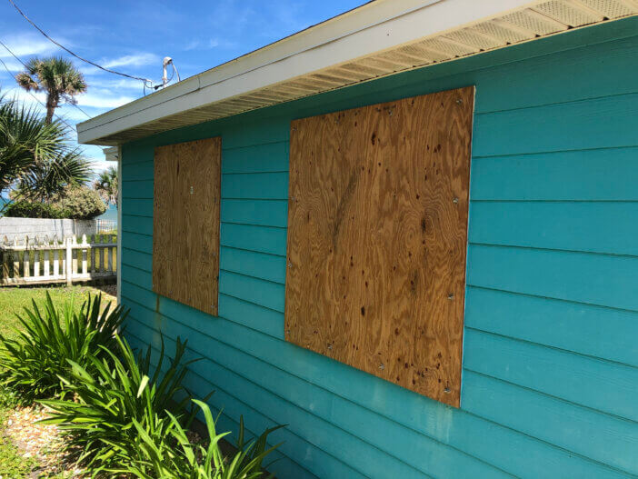 Homemade plywood covers the windows of a beach cottage in Florida in preparation for an oncoming hurricane.