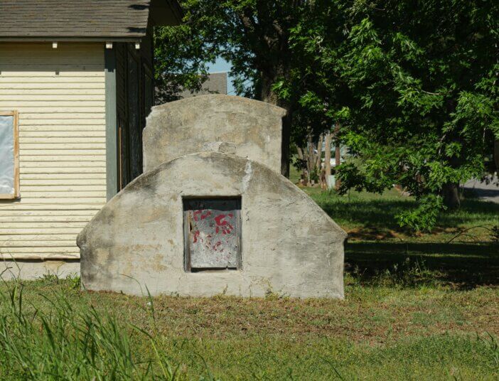 Concrete outdoor storm shelter outside a house