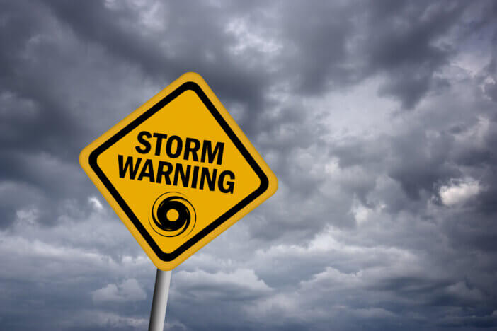 Storm warning sign over stormy sky