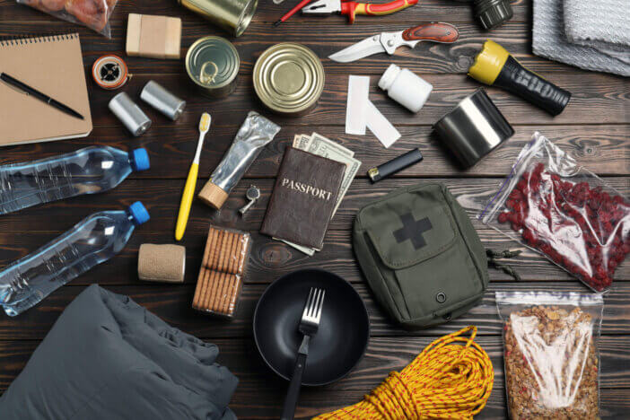 Disaster supply kit for earthquake on wooden table, flat lay