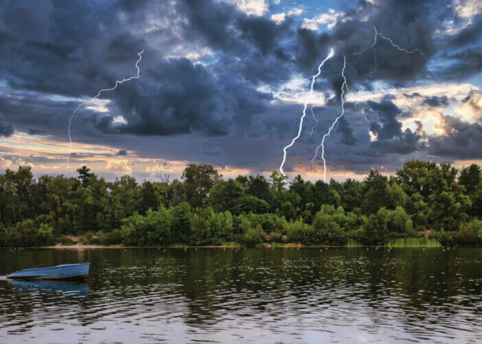 landscape empty boat on a forest lake-river under thunderclouds with lightning.