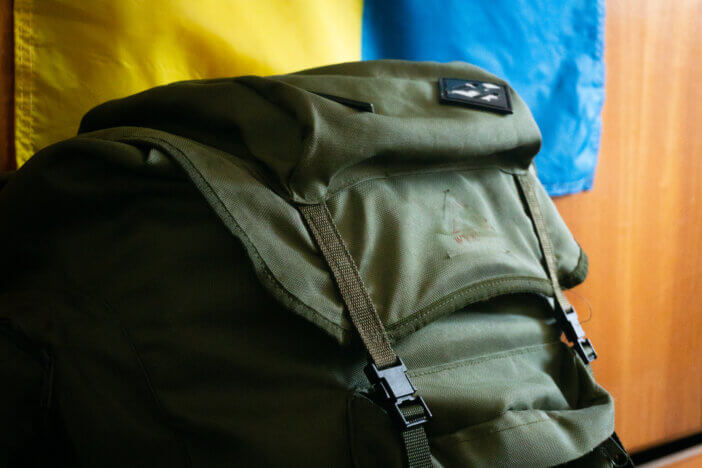 Military backpack. flag of ukraine on the background. close-up
