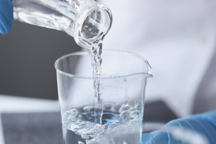 Scientist examines drinking water in laboratory. Presence of nitrates in water exceeding norm concept