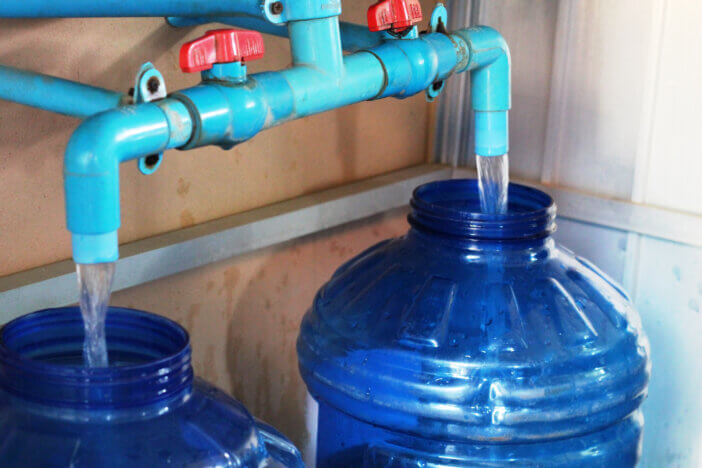 Filling water bottles with clean drinking water for consumption and sale in rural Cambodia