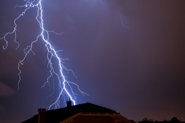 Powerful lightning strike above house roof in Croatia during storm