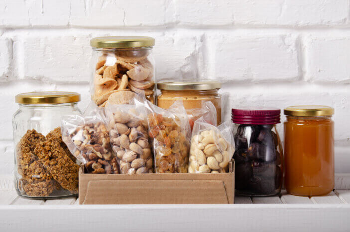 Set of long storage term mostly dry sweet energy foods on pantry shelf on brick wall background