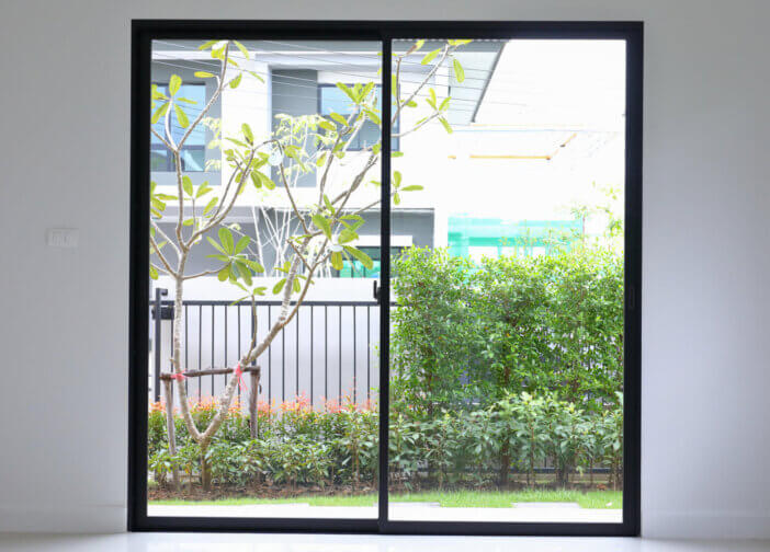 slide glass door with small garden landscaping in front of a new house