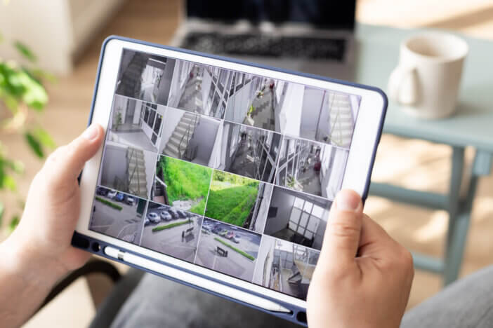 Man monitoring modern cctv cameras on digital tablet indoors. Surveillance security system. Work from home. close-up