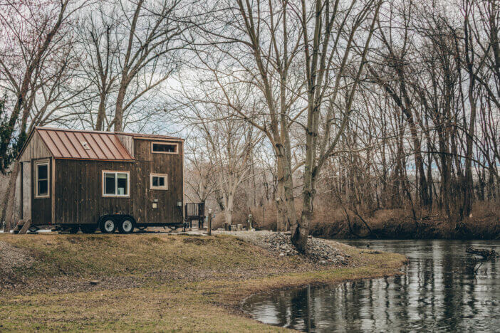A tiny home and tree reflection in a pond in New England.