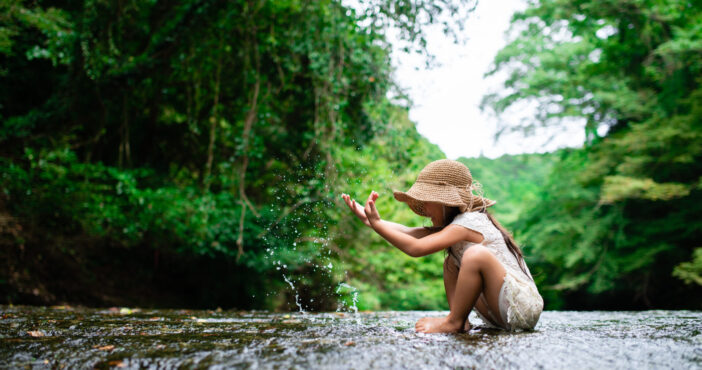 Girl playing in a mountain stream